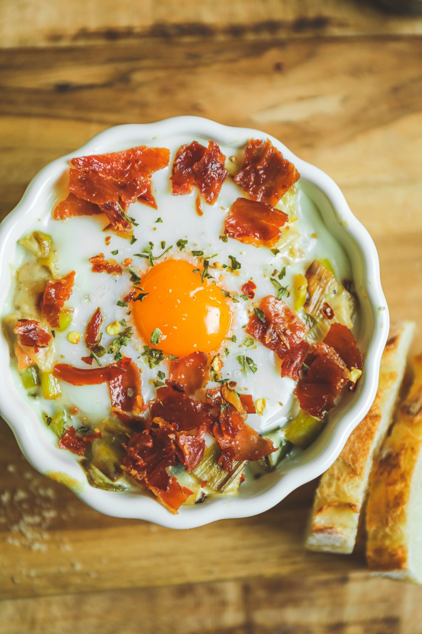 Oeuf cocotte aux St Jacques, fondue de poireaux et chips de jambon cru