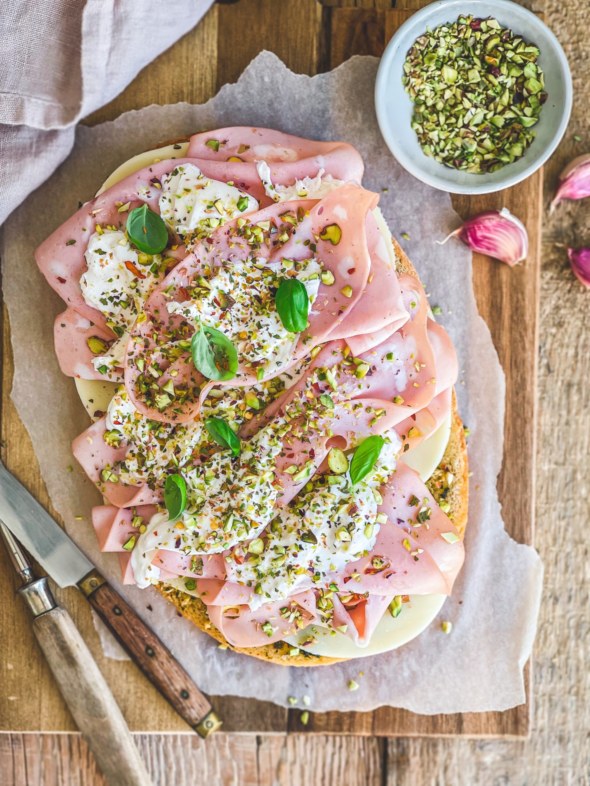 Bruschetta à la mortadella, provoletta, burrata et éclats de pistache